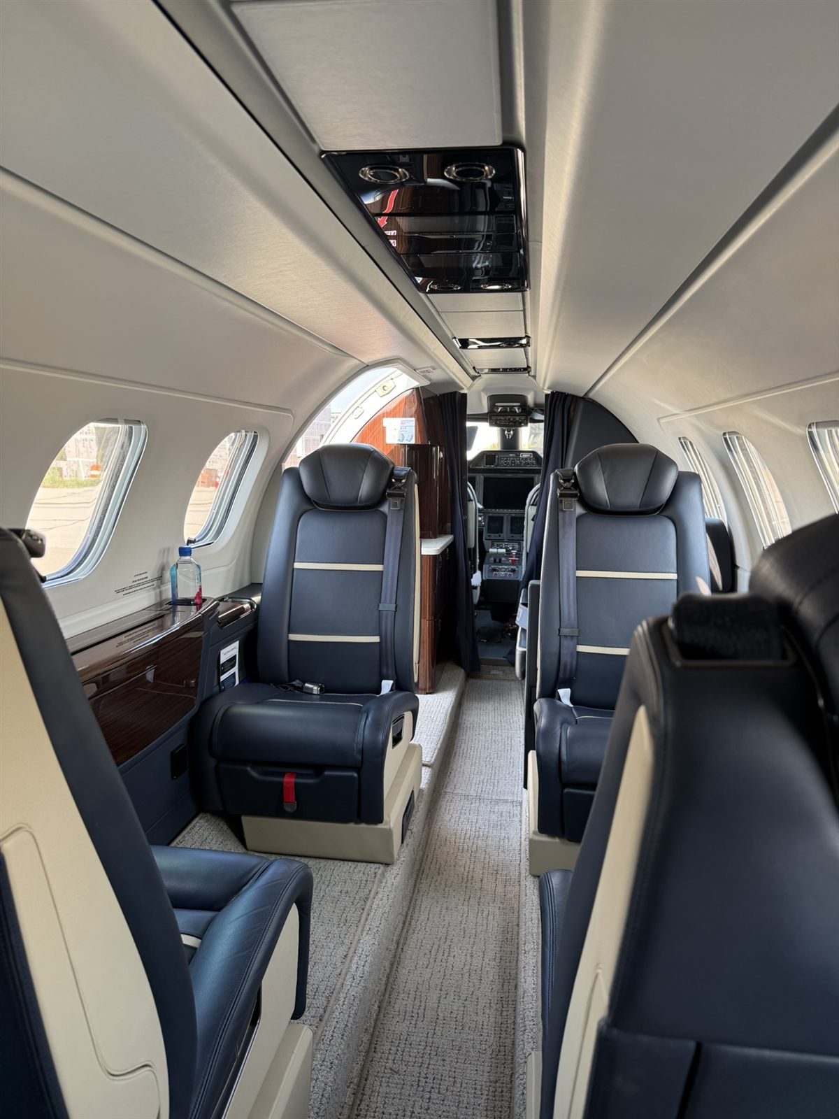 Phenom 300E light jet cabin with navy leather club seating