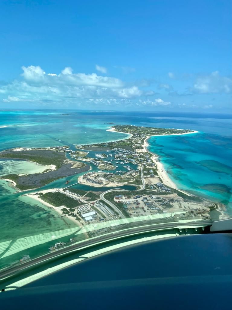 Final approach into an island airport over turquoise water