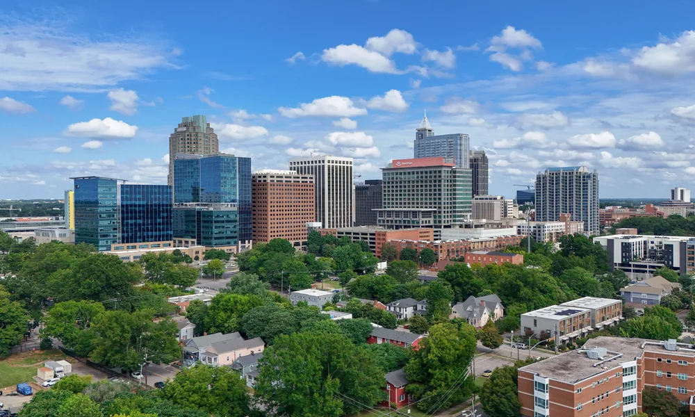 Downtown Raleigh skyline above tree lined streets on a summer day